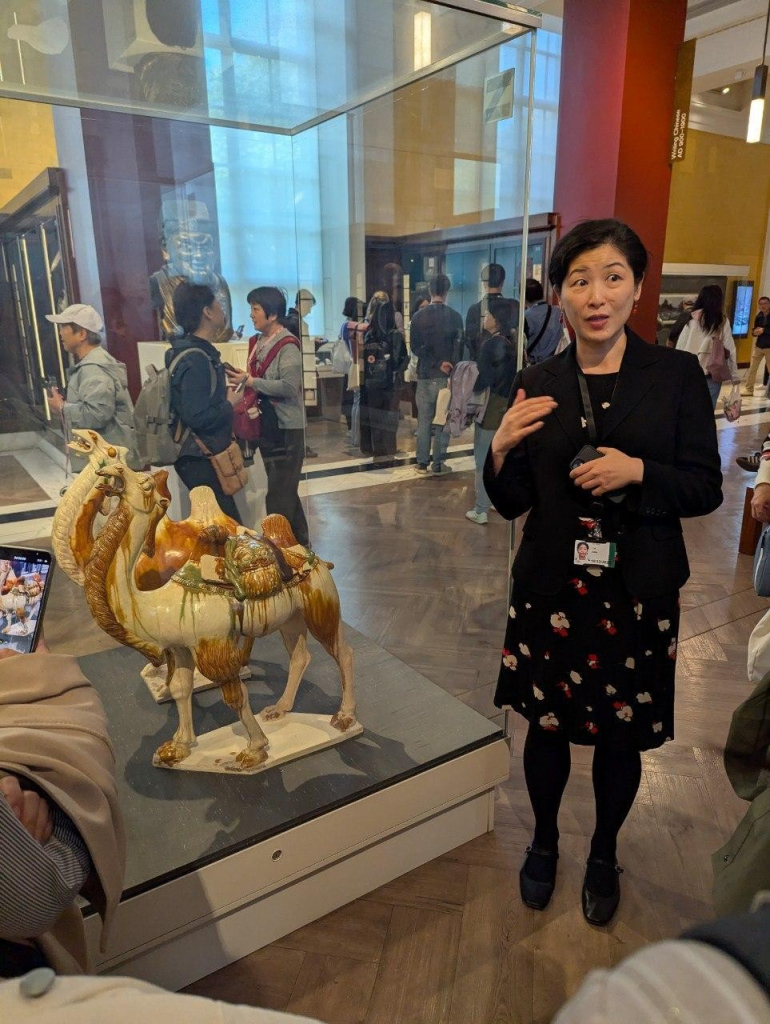 大英博物館中國文物展區的解說員介紹唐三彩駱駝的細節。A guide at the British Museum’s Chinese Antiquities Gallery explaining the details of a Tang Dynasty tri-colored glazed camel.